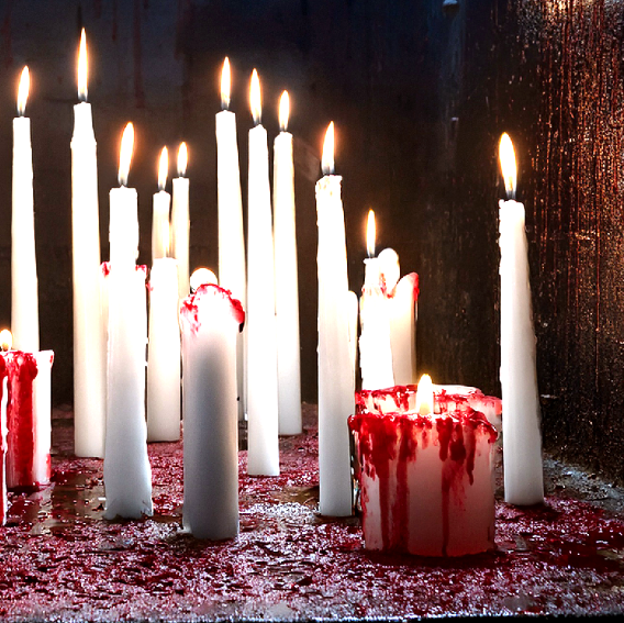 White candles with red wax on a dark background